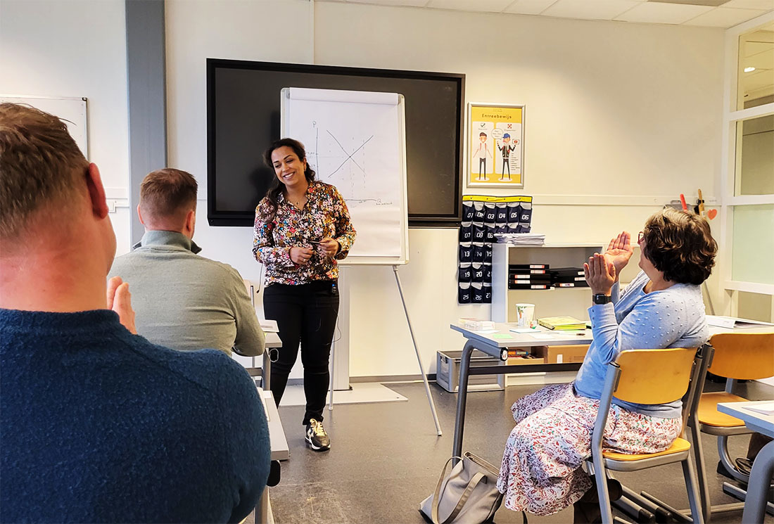 Lerares voor de klas met aantekeningen op een bord